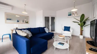 a living room with a blue couch and a table at Bed&Bcn Glories in Barcelona