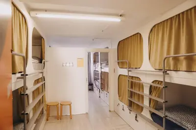 a dorm room with bunk beds and two stools at Onefam Ramblas in Barcelona