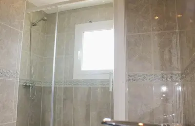 a bathroom with a shower with a window at House with Pool and Sea Views in Alella