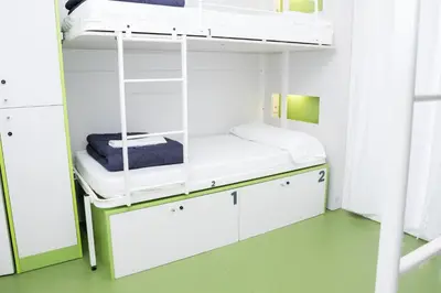 a room with a bunk bed with white cabinets at Sant Jordi Hostels Gracia in Barcelona