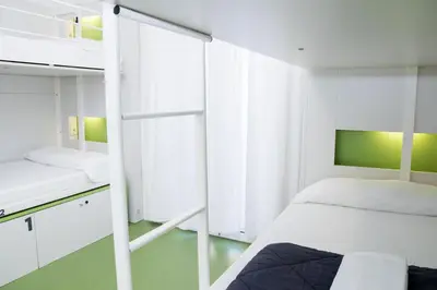 a small bedroom with a bed and a window at Sant Jordi Hostels Gracia in Barcelona