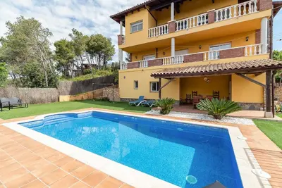 a swimming pool in front of a house at Casa Xixella a 15 min de Sitges in Olivella