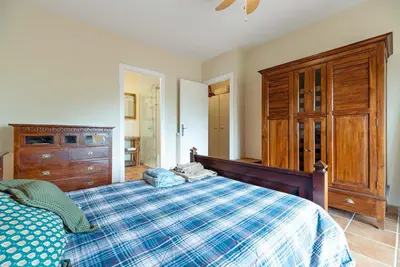 a bedroom with a bed and a wooden dresser at Casa Xixella a 15 min de Sitges in Olivella