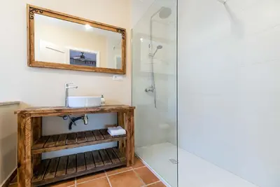 a bathroom with a sink and a mirror and a shower at Casa Xixella a 15 min de Sitges in Olivella