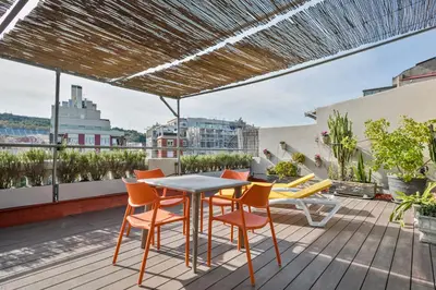 a patio with a table and chairs on a roof at Stay Together Barcelona Apartments in Barcelona
