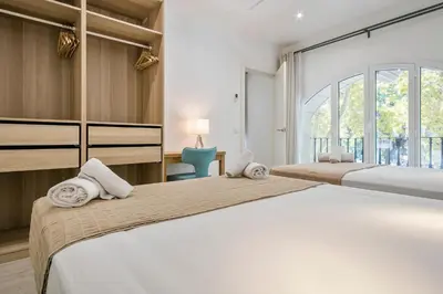 two beds in a room with a large window at Stay Together Barcelona Apartments in Barcelona