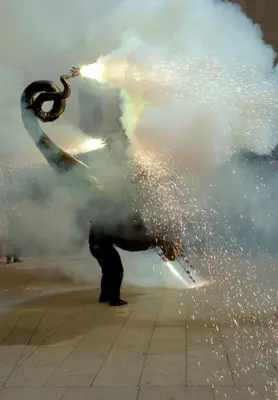 a man is standing on a sidewalk with a spray of water at Hotel Pere III El Gran in Vilafranca del Penedès