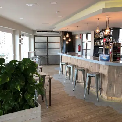 a bar in a restaurant with stools and a counter at Dynamic Hotels Caldetes Barcelona in Caldes d'Estrac