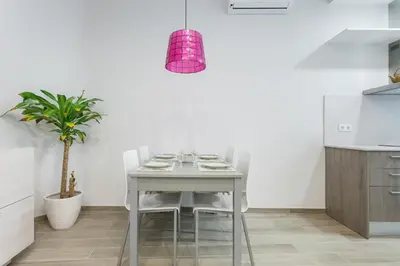 a kitchen with a table with chairs and a potted plant at Beautiful Apartment 20 minutes from city center in Hospitalet de Llobregat