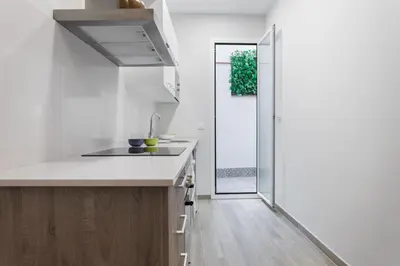 a white kitchen with a sink and a window at Beautiful Apartment 20 minutes from city center in Hospitalet de Llobregat