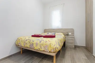 a bedroom with a bed and a dresser in it at Beautiful Apartment 20 minutes from city center in Hospitalet de Llobregat