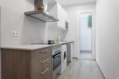 a white kitchen with a sink and a stove at Beautiful Apartment 20 minutes from city center in Hospitalet de Llobregat