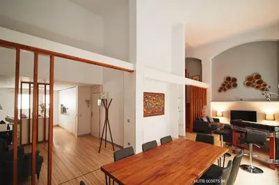 a living room with a wooden table and a piano at Alcam Alio Cine in Barcelona