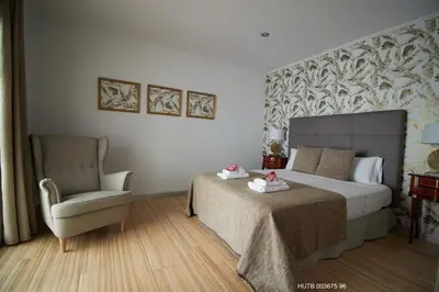 a bedroom with a large bed and a chair at Alcam Alio Cine in Barcelona