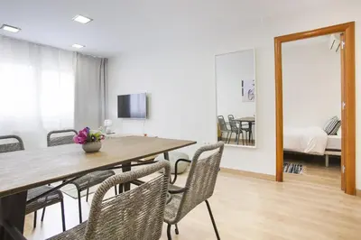 a dining room with a table and chairs and a mirror at Tendency Apartments Forum 2 in Barcelona