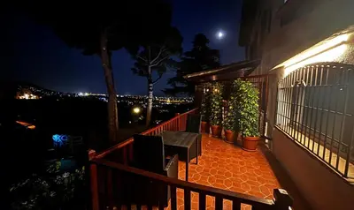 a balcony with a bench and potted plants at night at B&B Premium in Premia de Dalt
