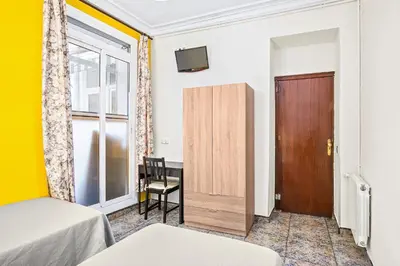 a bedroom with a bed and a wooden door at Hostal Santa Ana in Barcelona