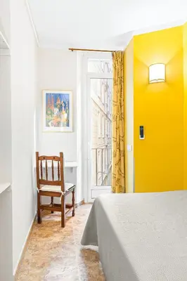 a bedroom with a bed and a tv on a wall at Hostal Santa Ana in Barcelona