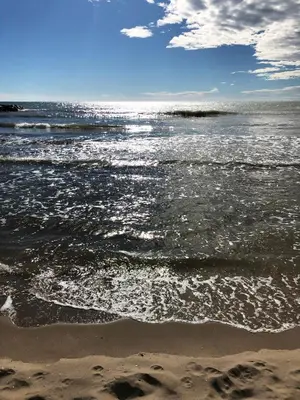 a beach with the ocean and the shoreline at Espectacular ático dúplex con vistas al mar in Cunit