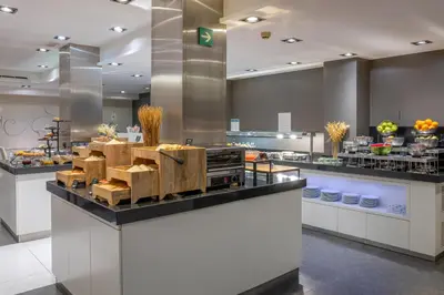a restaurant with a counter with food on it at Hotel Ciutadella Barcelona in Barcelona