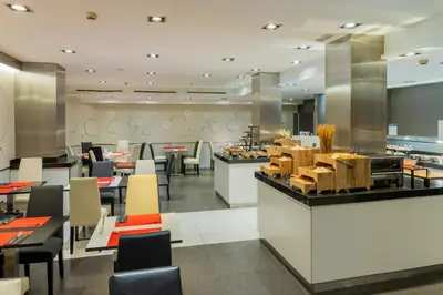 a restaurant with tables and chairs and a buffet at Hotel Ciutadella Barcelona in Barcelona