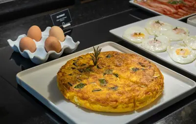 a plate with a pie on a table with eggs at Hotel Ciutadella Barcelona in Barcelona