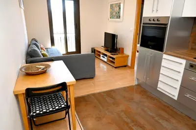 a kitchen and living room with a couch and a table at Homenfun Barcelona Plaza España in Barcelona
