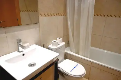 a bathroom with a sink and a toilet and a tub at Homenfun Barcelona Plaza España in Barcelona