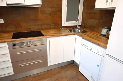 a kitchen with white cabinets and a sink at Homenfun Barcelona Plaza España in Barcelona