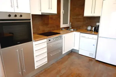 a kitchen with white cabinets and white appliances at Homenfun Barcelona Plaza España in Barcelona