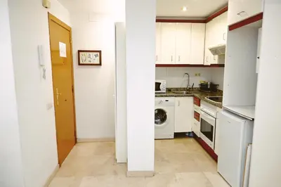 a kitchen with white cabinets and a washer and dryer at Homenfun Barcelona Sagrada Familia Lepanto in Barcelona