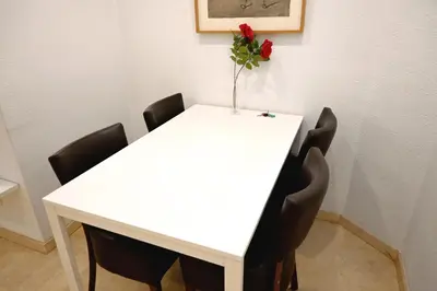 a white table with chairs and a vase with a rose at Homenfun Barcelona Sagrada Familia Lepanto in Barcelona