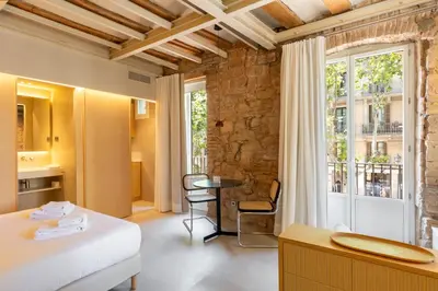 a room with a bed and a table and a window at Decô Apartments Barcelona-Born St. in Barcelona