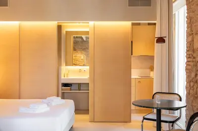 a room with a bed and a table and a kitchen at Decô Apartments Barcelona-Born St. in Barcelona