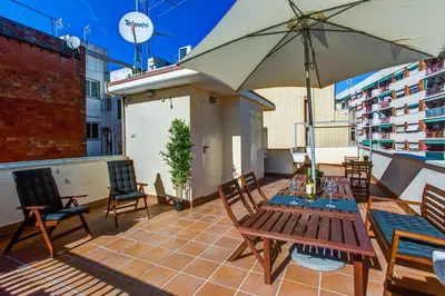 a patio with a table and an umbrella on a roof at Feriapiso Apartments Palmer in Hospitalet de Llobregat