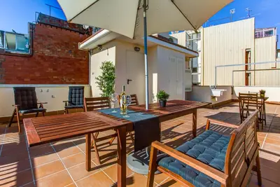 a patio with a table and chairs and an umbrella at Feriapiso Apartments Palmer in Hospitalet de Llobregat