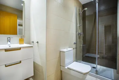 a bathroom with a toilet and a glass shower at Feriapiso Apartments Palmer in Hospitalet de Llobregat
