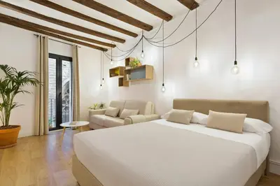 a bedroom with a white bed and a couch at Ola Living Born in Barcelona