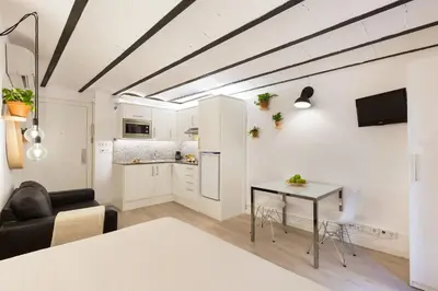 a living room with a table and a kitchen at Ola Living Born in Barcelona