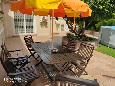 a table and chairs with an umbrella on a patio at LOFT A 20' DE BARCELONA Y 7' DE LA UAB. in Barbera del Valles