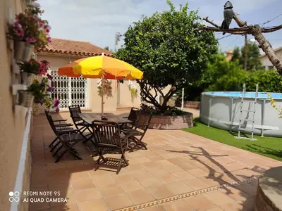 a patio with a table and chairs and an umbrella at LOFT A 20' DE BARCELONA Y 7' DE LA UAB. in Barbera del Valles