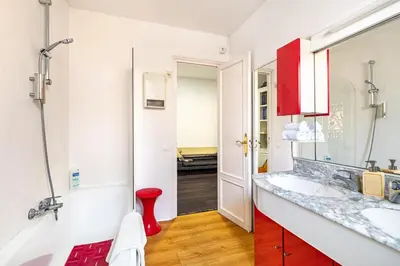 a bathroom with a sink and a red cabinet at Luxury Penthouses 1 in Barcelona