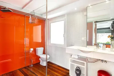 an orange bathroom with a toilet and a sink at Luxury Penthouses 1 in Barcelona