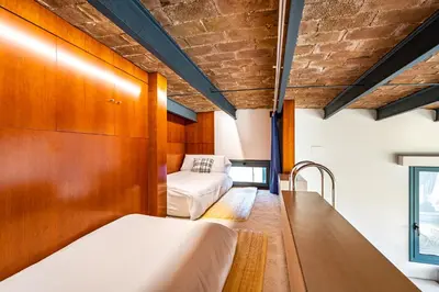 two beds in a room with wood paneling at Luxury Penthouses 2 in Barcelona