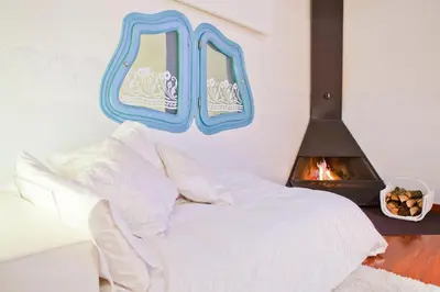 a bedroom with a white bed and a fire place at Luxury Penthouses 2 in Barcelona