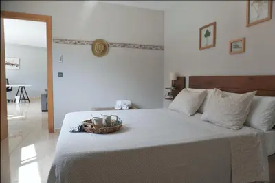 a white bedroom with a bed with a basket on it at BlueLine 25km BCN-Piscina, sauna y vistas al mar in Mataró