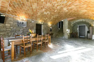 a dining room with a wooden table and chairs at Masia el Prat in El Pont de Vilomara