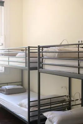 a man laying on a bunk bed reading a newspaper at 360 Hostel Centro in Barcelona