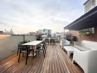 a deck with tables and chairs on a roof at Enjoybcn Gaudi Apartments in Barcelona