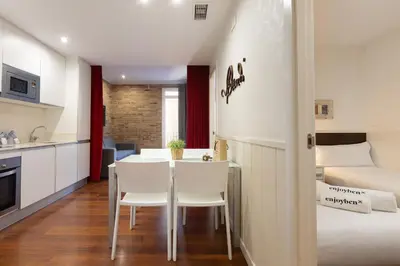 a small apartment with a table and chairs and a bed at Enjoybcn Gaudi Apartments in Barcelona